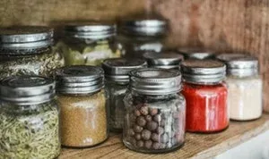 Bocaux en verre remplis d'épices sur une étagère en bois